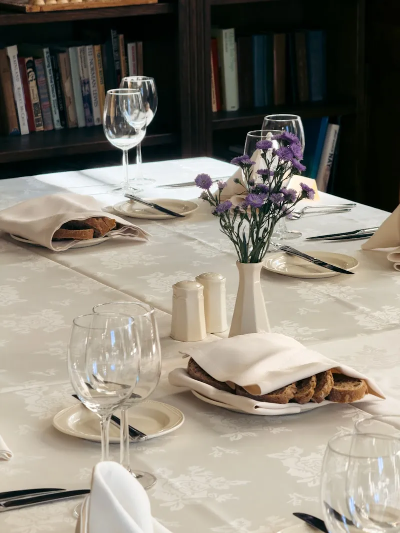 A white-linen table setting with flowers