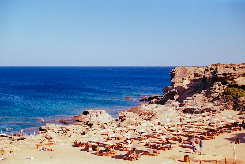 Beach umbrellas on a rocky Mediterranean cove