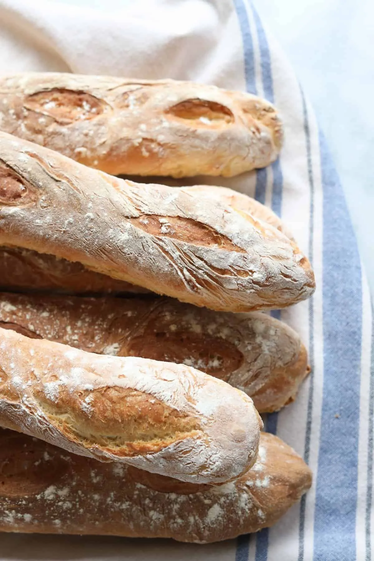 Freshly baked baguettes on a striped linen towel