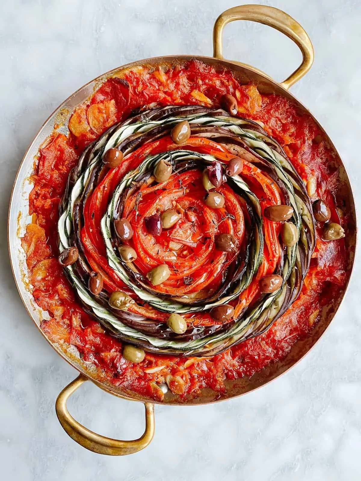 Ratatouille arranged in a spiral in a copper pan