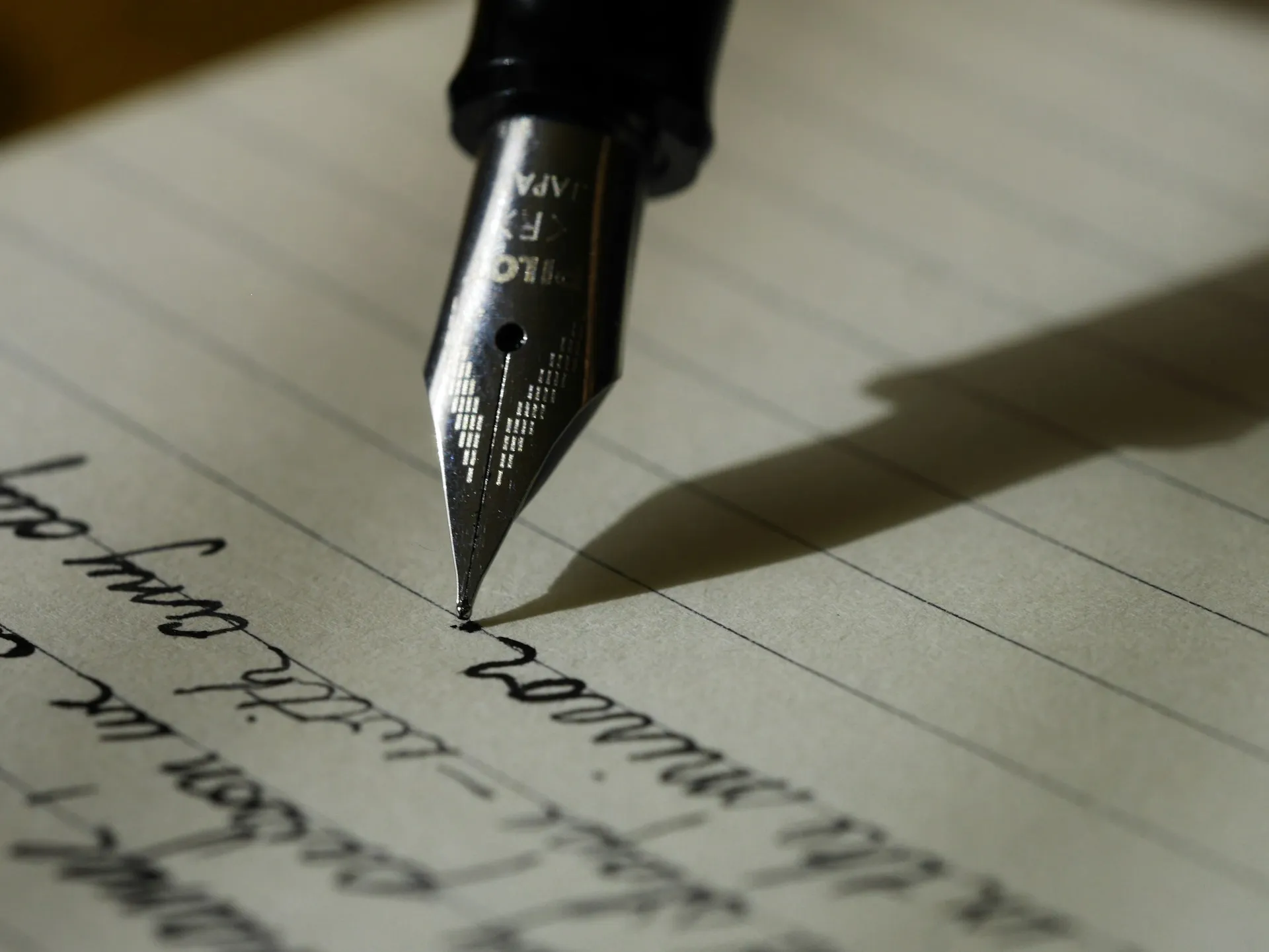 A fountain pen writing on lined paper
