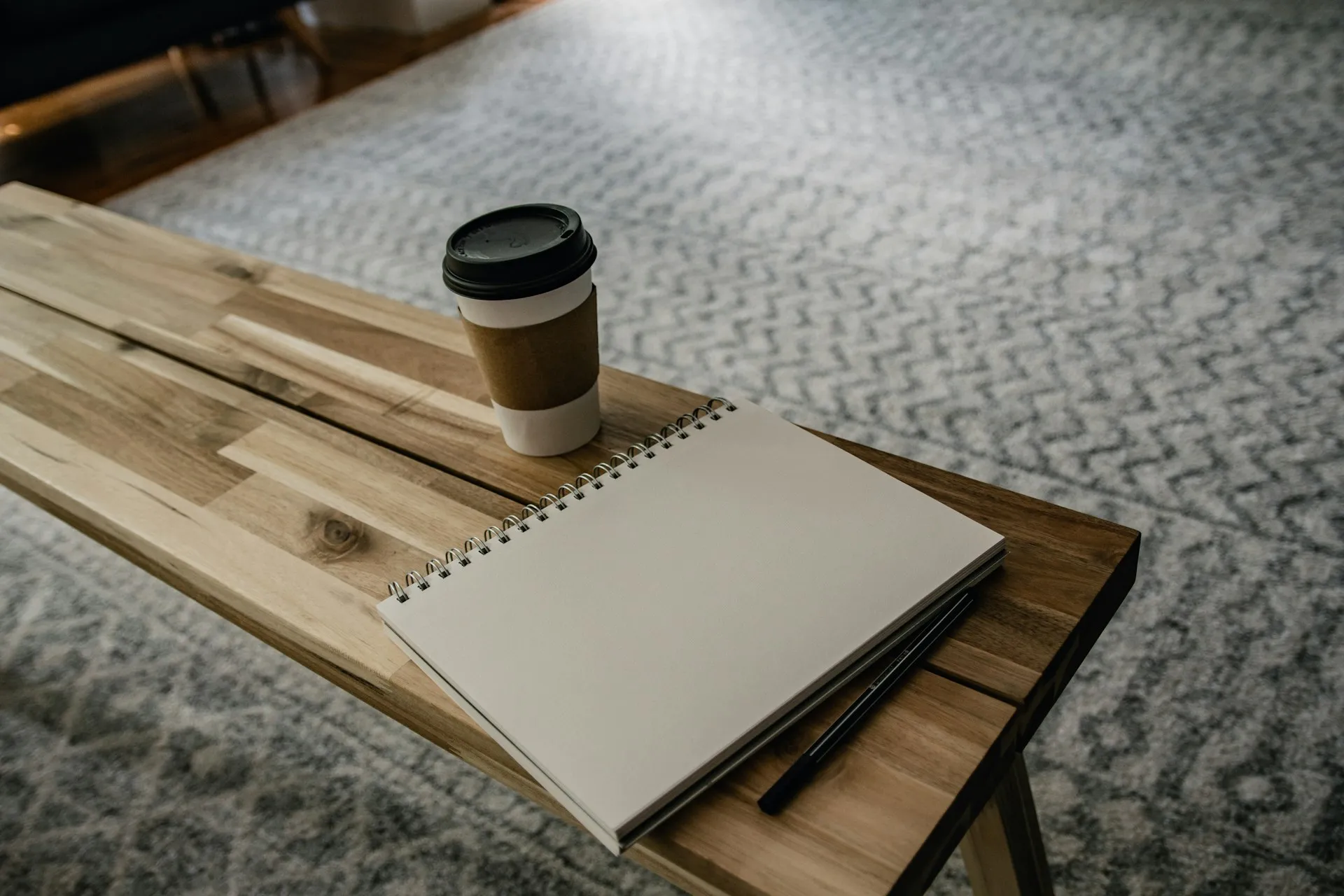 An open notebook and coffee on a warm wooden desk